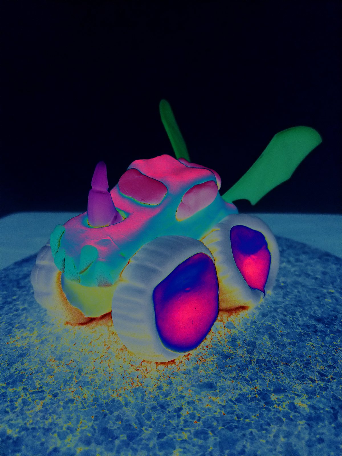 A toy truck rendered in glowing pink, green and blue against a blue ground.