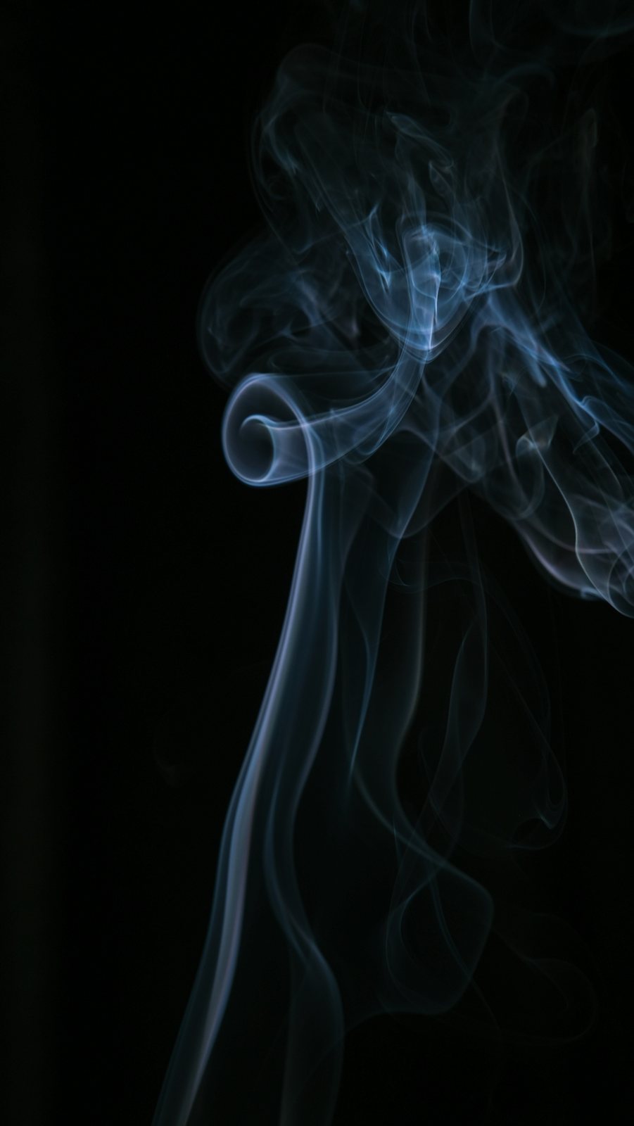 A thin ribbon of smoke rising against black.