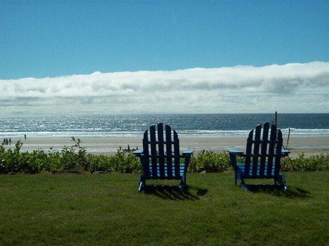 The author’s chosen image: two deck chairs on the grass above a wide beach.
